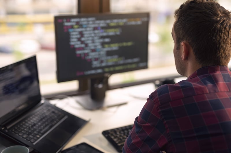 Man looking at computer screens