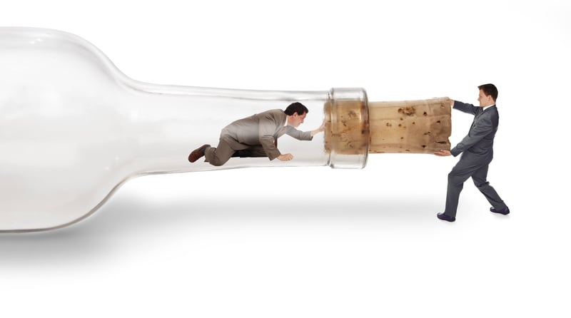 Bottle with a man inside it pushing at the cork