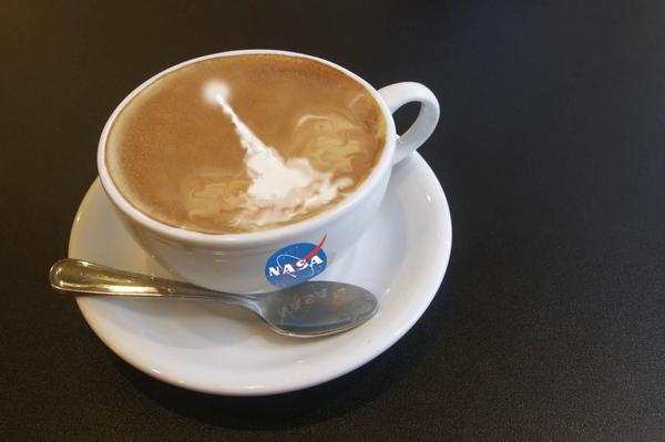 Coffee cup with NASA logo and a blast off drawn in the foam