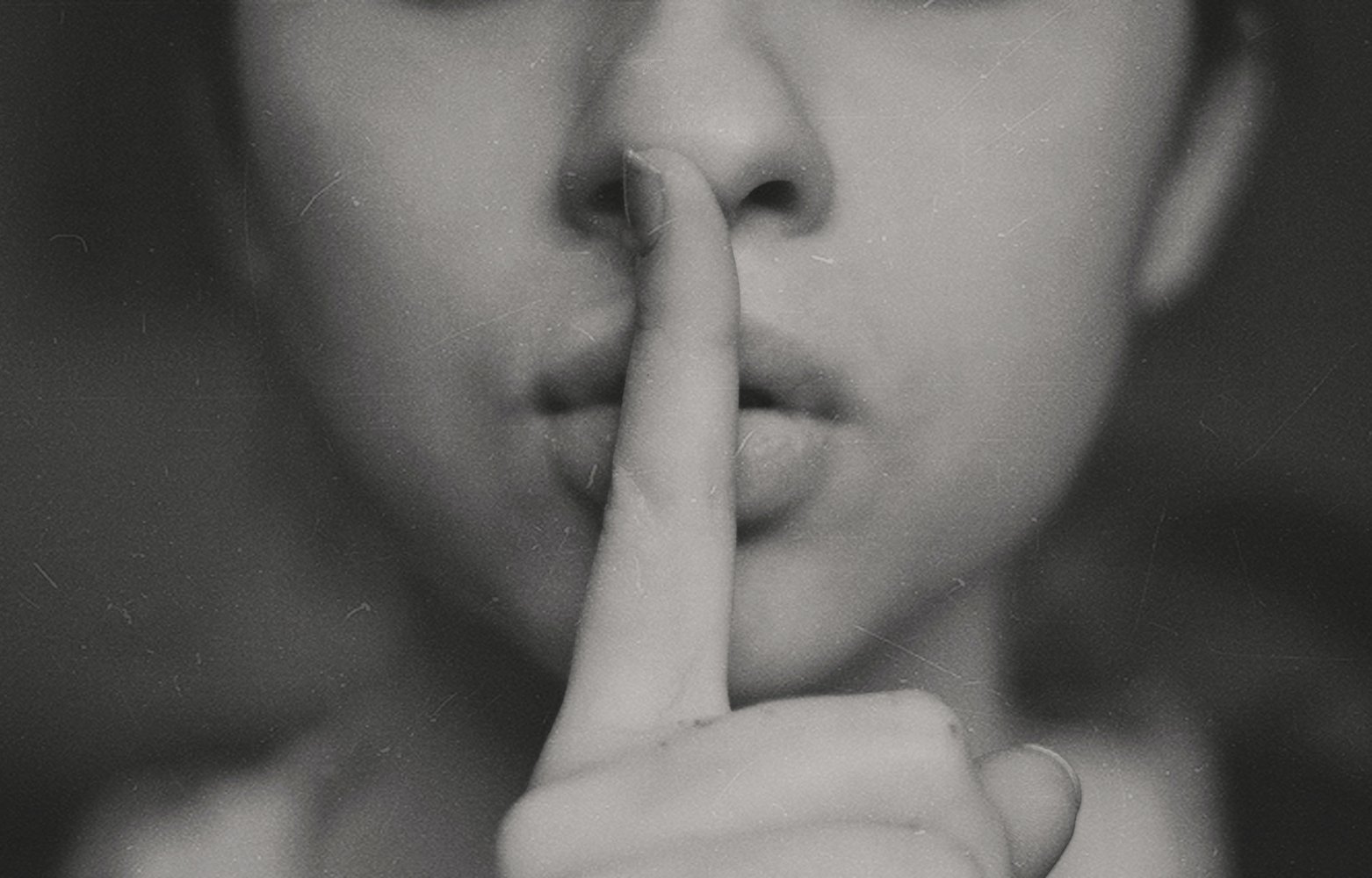 Woman holding her finger to her lips as if to say 'silence please'