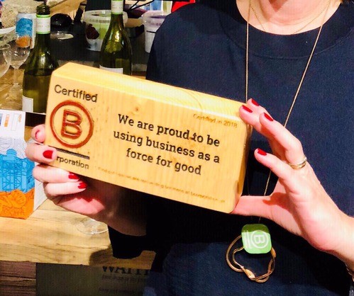 Liz the Chief Happiness Officer holding the B Corp block